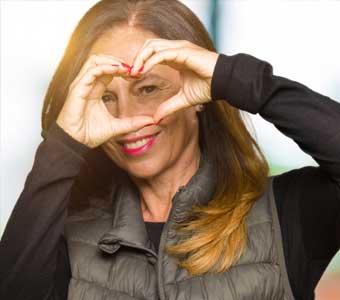 A woman making a heart shape with her hands