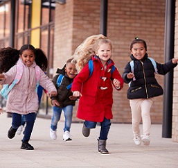 children running into school with bookbags