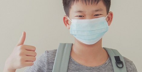 Child giving thumbs up after receiving Covid-19 vaccine