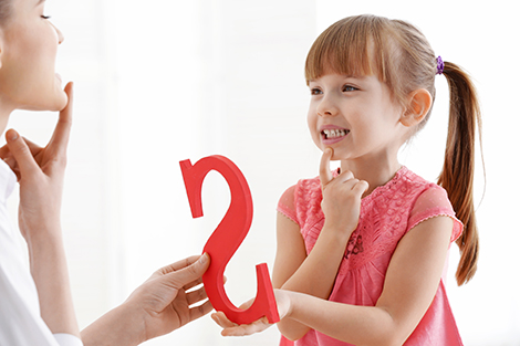 Girl receiving instruction from speech pathologist on proper speech pronunciation