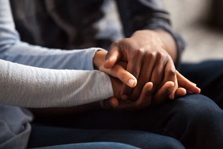 Two sets of hands holding each other