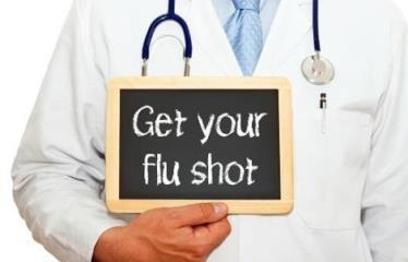 Doctor holding sign that says get your flu shot