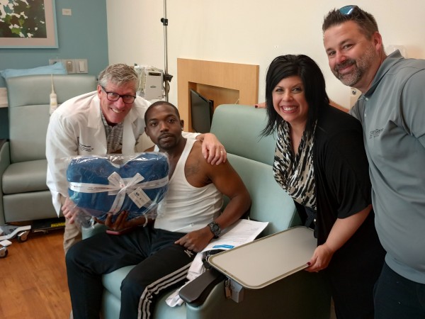 A MetroHealth patient receiving a gift blanket with Dr. Michael Harrington present