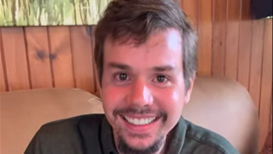 Andrew Horner smiling at home in his living room