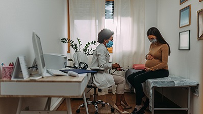 Pregnant woman and Obgyn in exam room