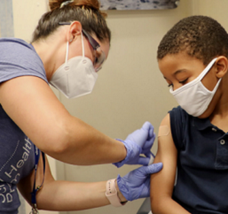 Nurse giving vaccination to child