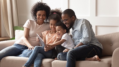 Family sitting on couch reading a book together