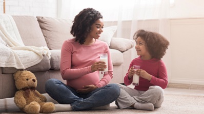Pregnant woman sitting on living room floor with your daughter