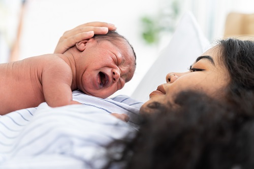 Woman with newborn baby resting on her chest