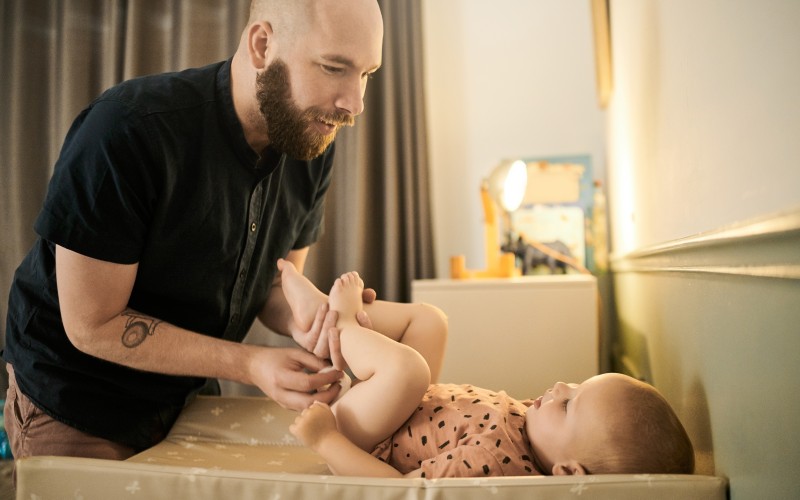 Father cleaning up his baby after changing a diaper