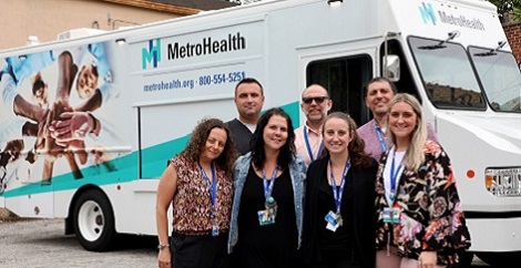 Expanded mobile team standing in front of van