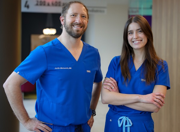 Dr. Justin Mistovich and Julia K. LoPresti, PA-C standing in scrubs