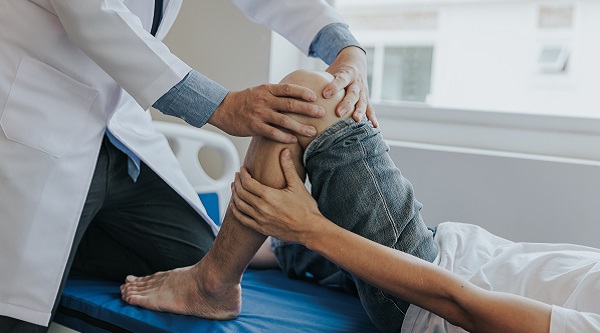 physician adjusting childs knee in clinic