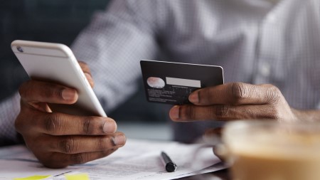 Person holding credit card and phone