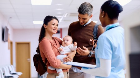 Family holding baby in medical office