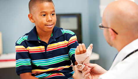 Pediatric patient getting wrist wrapped by pediatrician