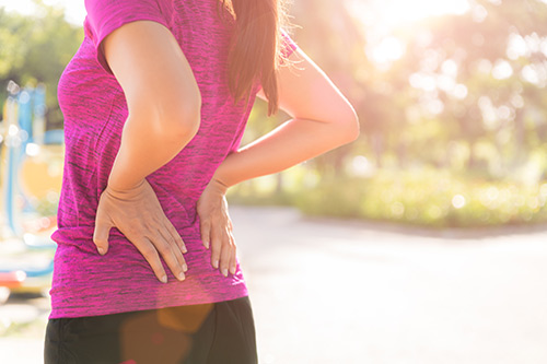 Woman stretching her lower back to maintain proper alignment