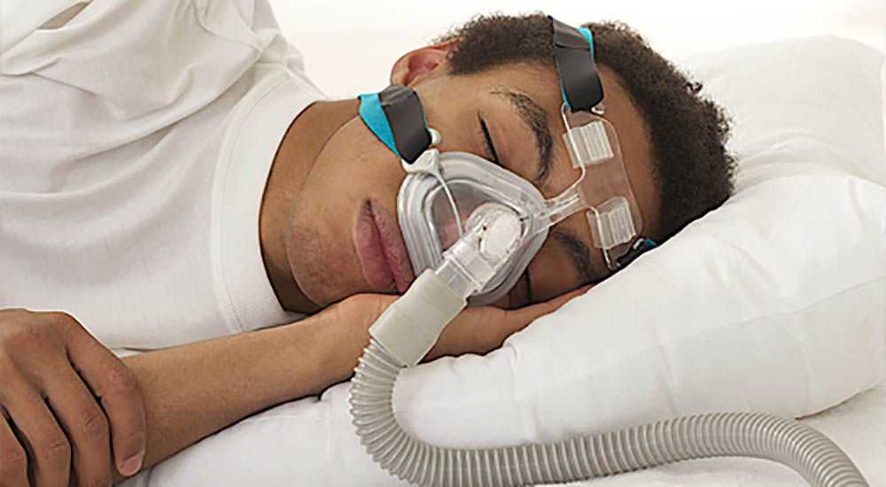 Man wearing CPAP mask to assist with sleeping