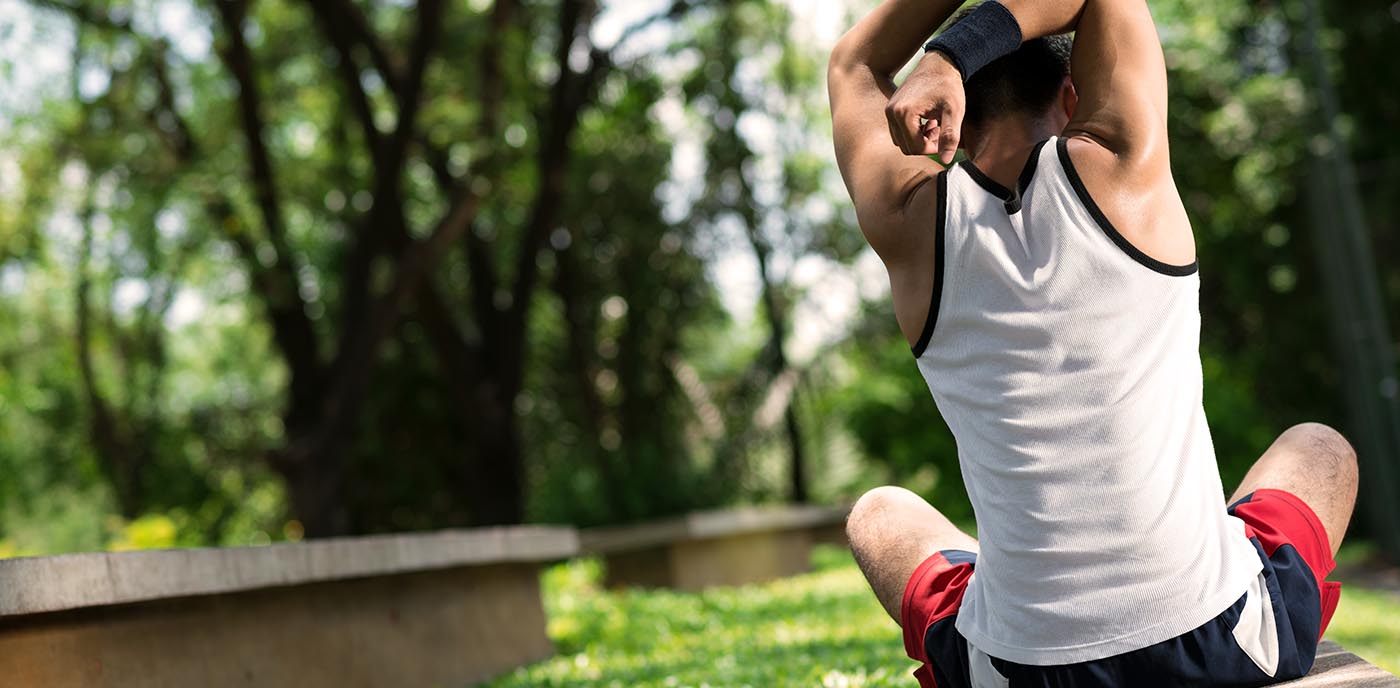 Picture of man stretching while sitting on a deck