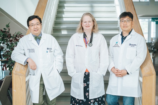 Dr. Tse and staff standing on a staircase