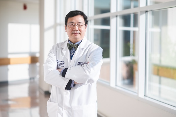 William Tse, MD in hallway with arms crossed