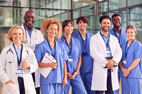 group photo of virtual care team standing together in white coats and scrubs