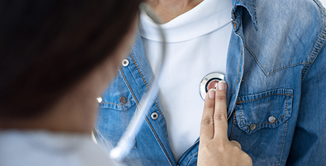 Doctor using stethoscope on patient during cardiology visit for heart health