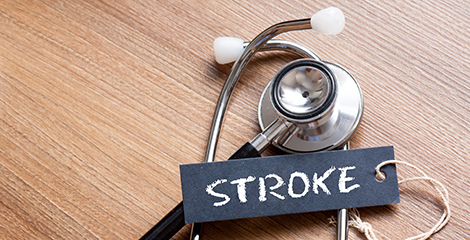 Stethoscope on table with a black tag on top that has the word stroke on it in white letters