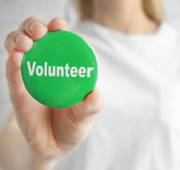 Woman holding her volunteer badge