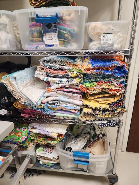 A large collection of quilted blankets stored on shelves