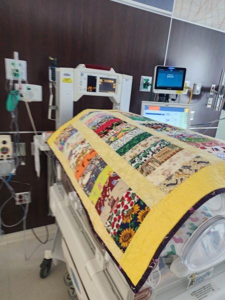 A blanket covering a NICU bed