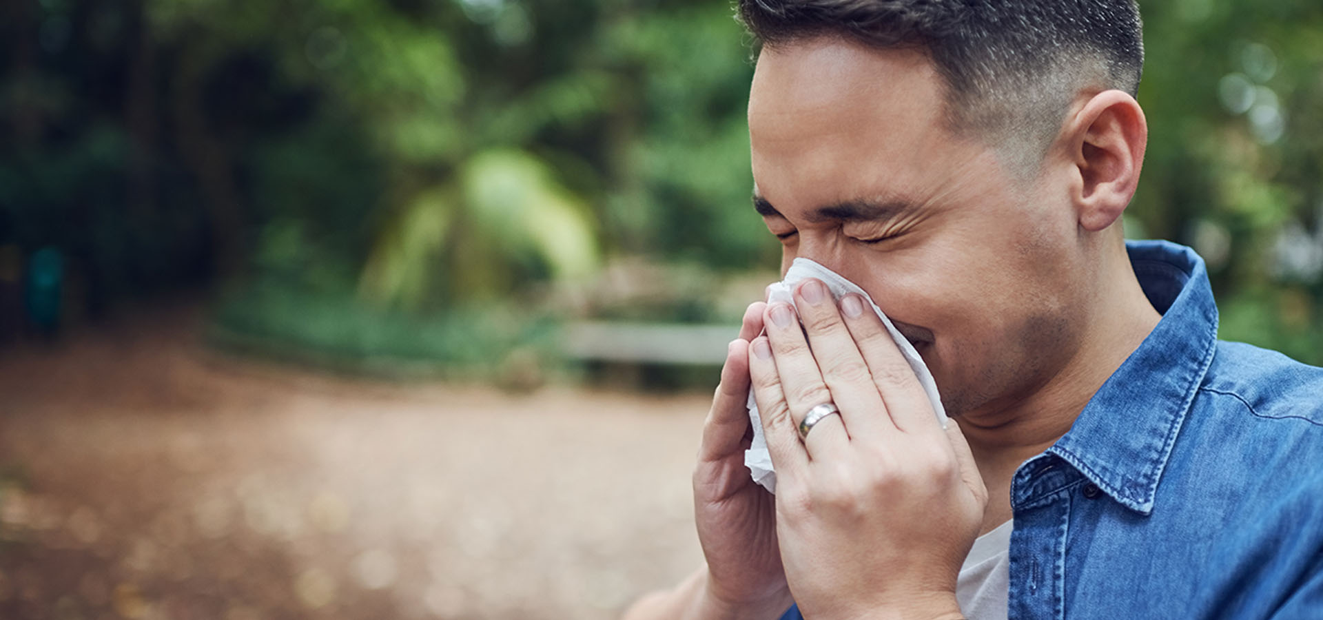 Man sneezing into a tissue
