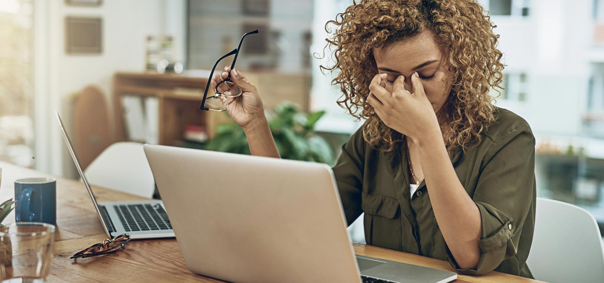 Women at computer touching eyes