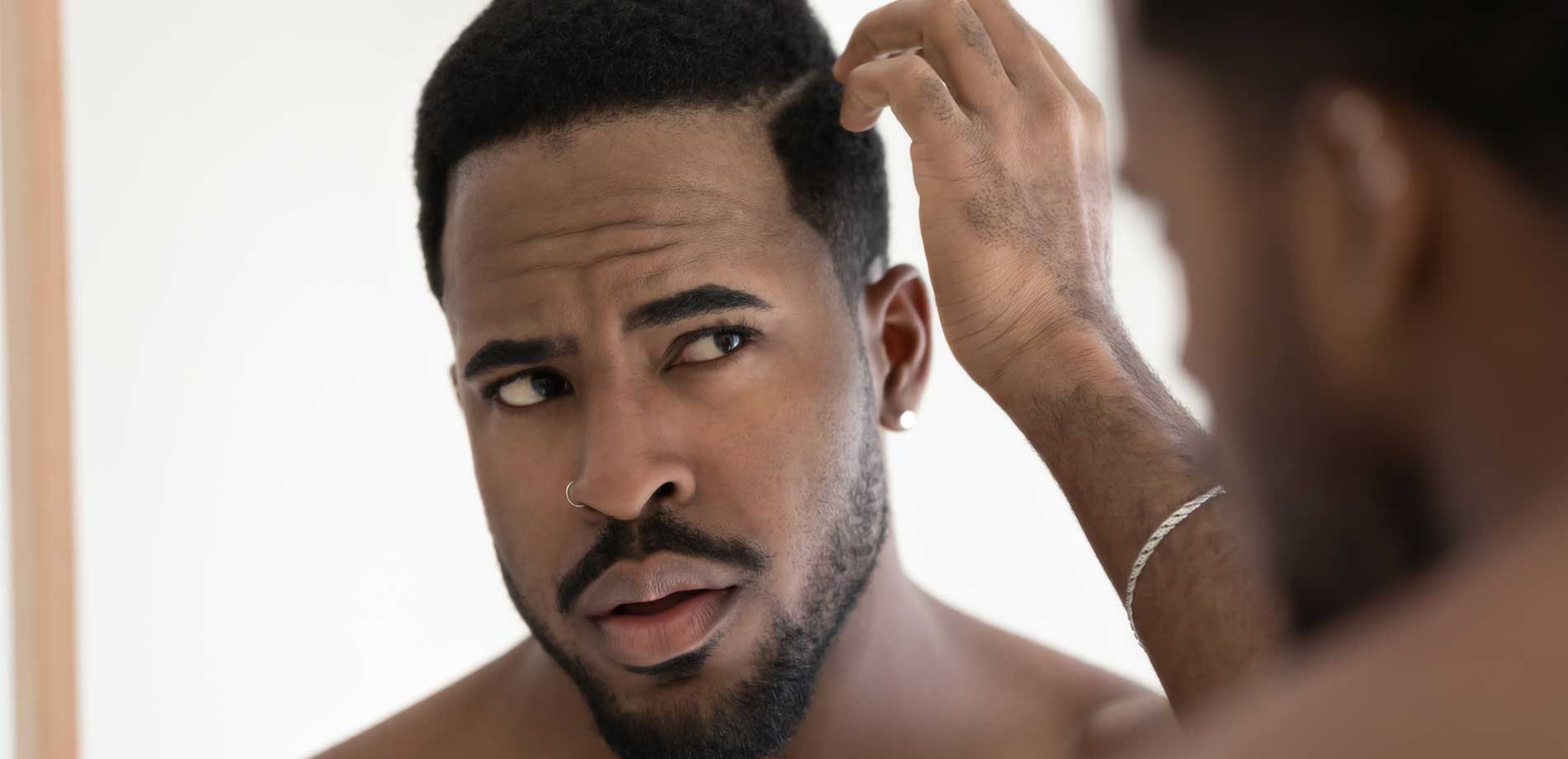 black man looking in mirror