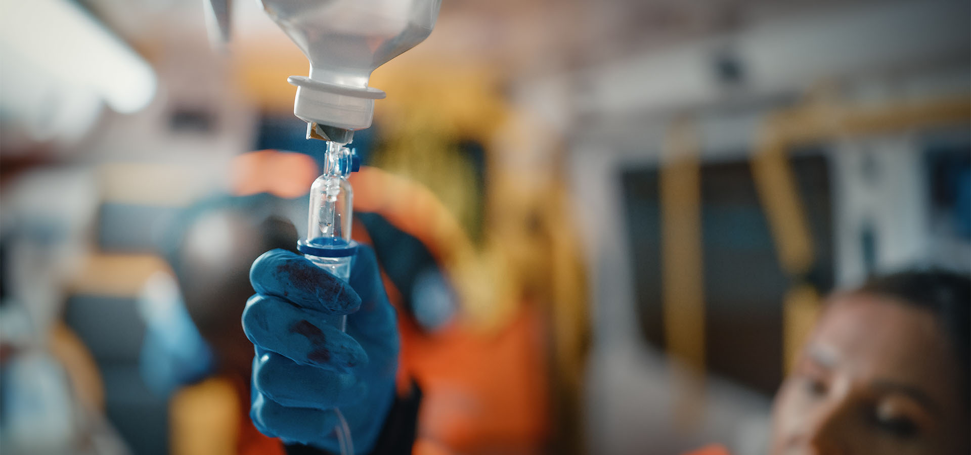 Hand adjusting IV fluid flow in an ambulance
