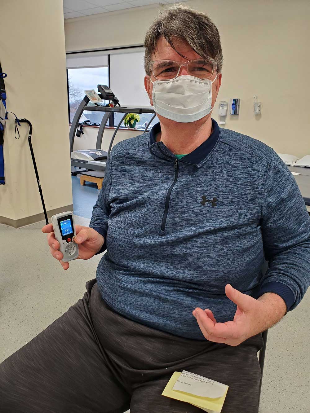 Patient demonstrates using new technology for calming back pain.