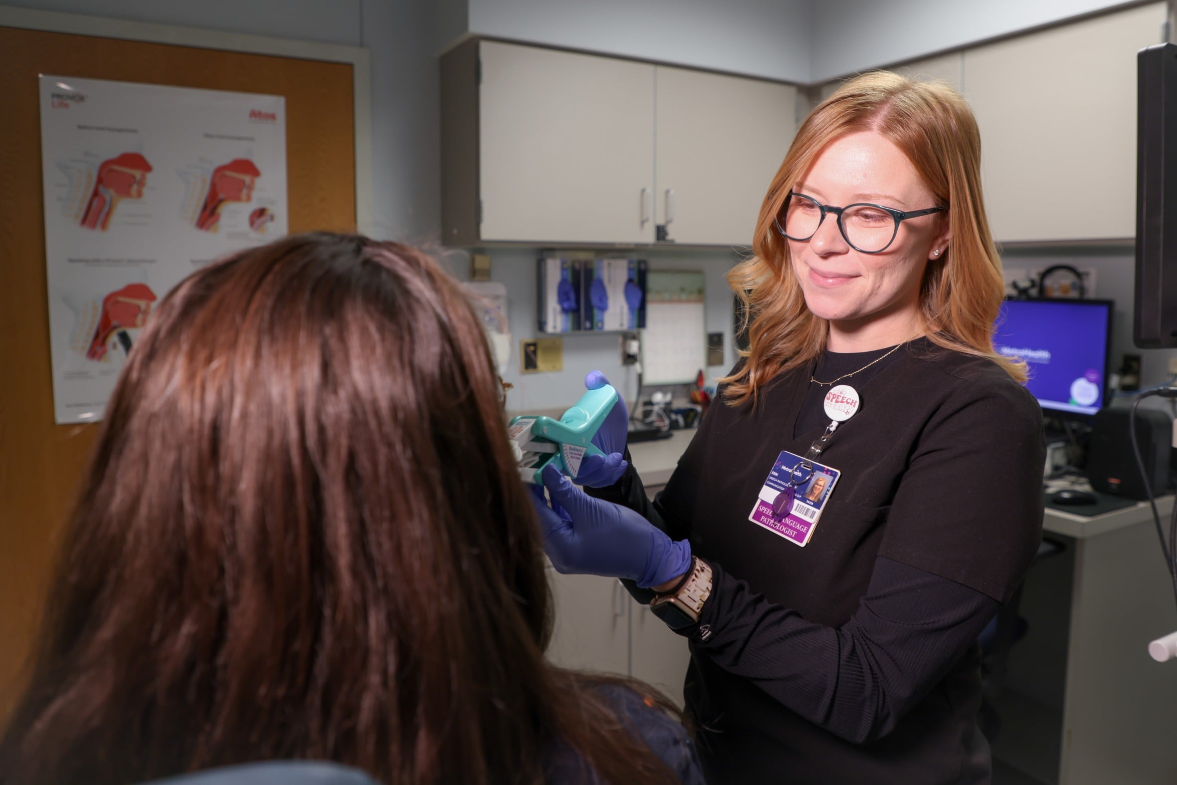 Speech-language pathologist works with patient