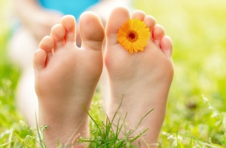 A person relaxing barefoot on grass