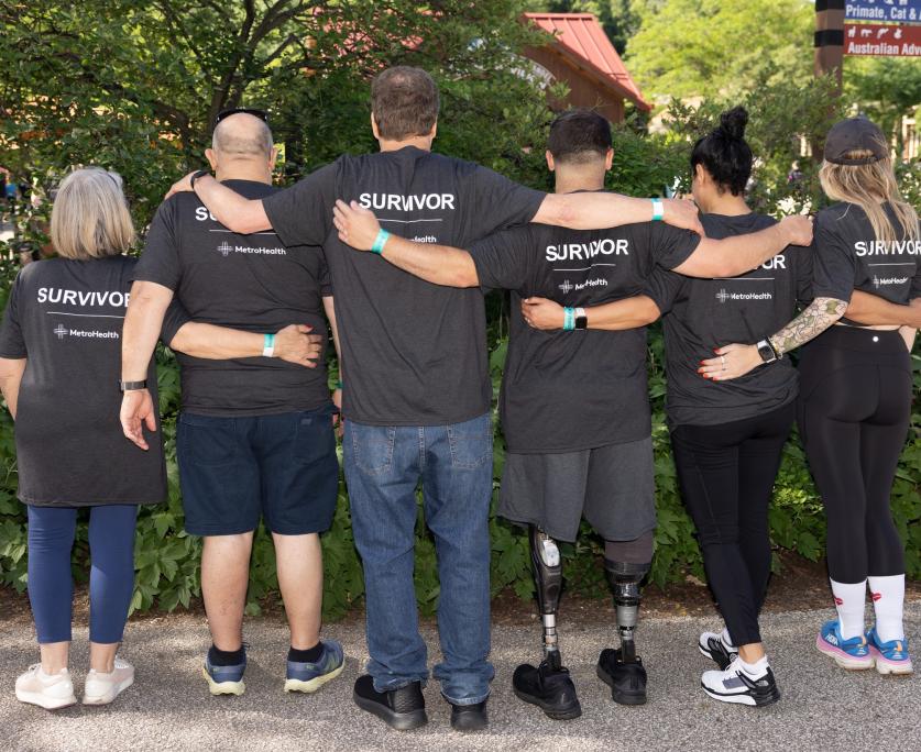 People wearing shirts labeled "SURVIVOR" standing shoulder to shoulder