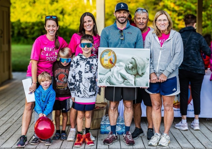 Katherine and David Corvi with their family and a photo of Charlie