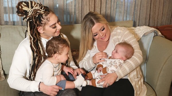 Moms with their babies sitting on a couch