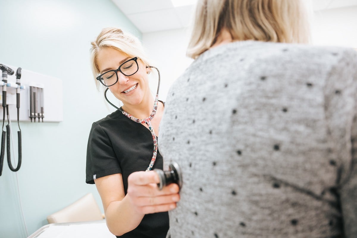 A MetroHealth provider checks a patient's breathing