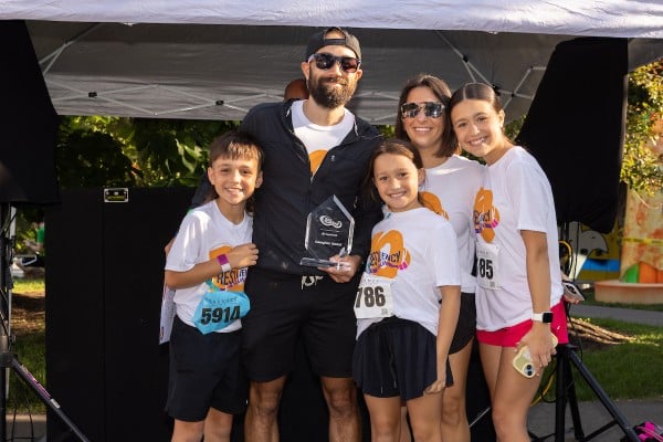 Andrew Neading accepting the Caregiver Award with his family