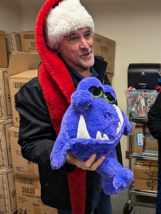 Matt "Ogre" Whaley wearing a Santa hat and holding a stuffed animal