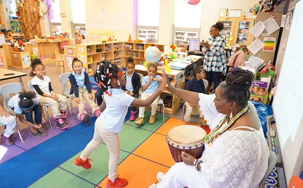 Classroom with teacher high-fiving student