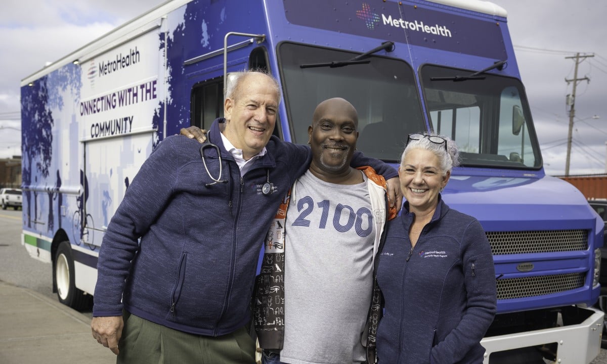 MetroHealth providers and a community member standing outside a mobile unit
