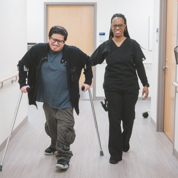 Healthcare worker with patient walking in hallway