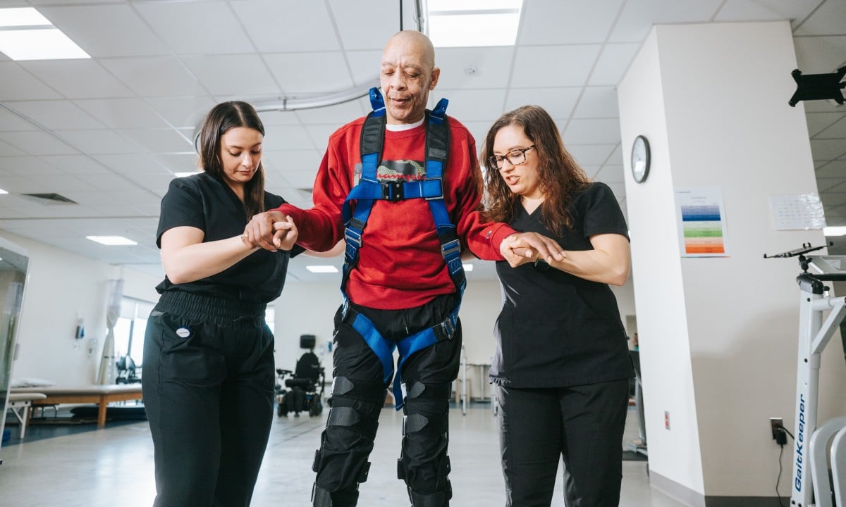 A rehabilitation patient walking with assistance