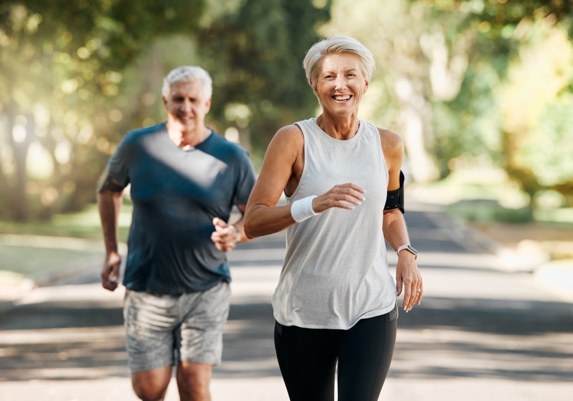 An elderly woman and man jogging in a park