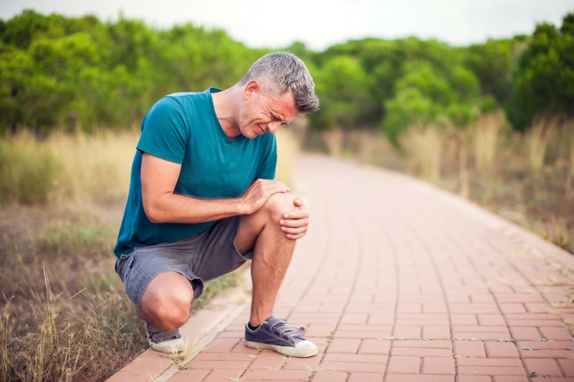 A runner holding his knee in pain